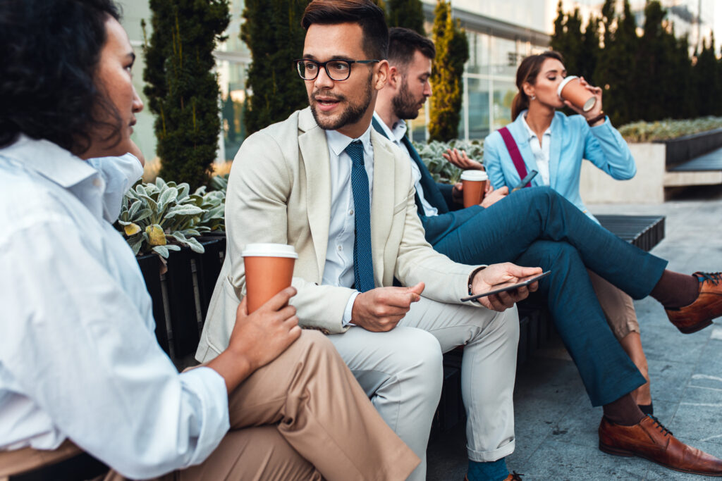 Profesionales conversando en un descanso durante una jornada corporativa