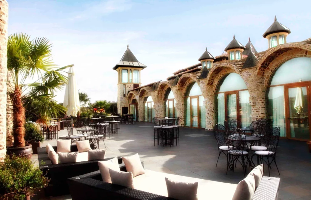 Terraza exterior de Aldea Santillana con arcos de piedra, torres y zona de descanso para eventos corporativos