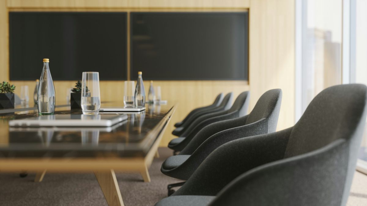 Sala de reuniones corporativa moderna con mesa larga, sillas ejecutivas y pantallas para evento empresarial estratégico