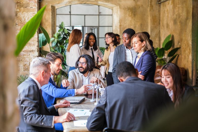Equipo profesional reunido en un espacio luminoso y natural durante una jornada corporativa fuera de la oficina.